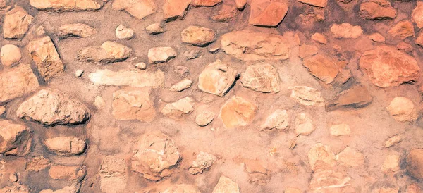 Masonry wall of stones with irregular pattern texture background