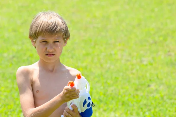 Junge spielt an Sommertag mit Wasserpistole — Stockfoto