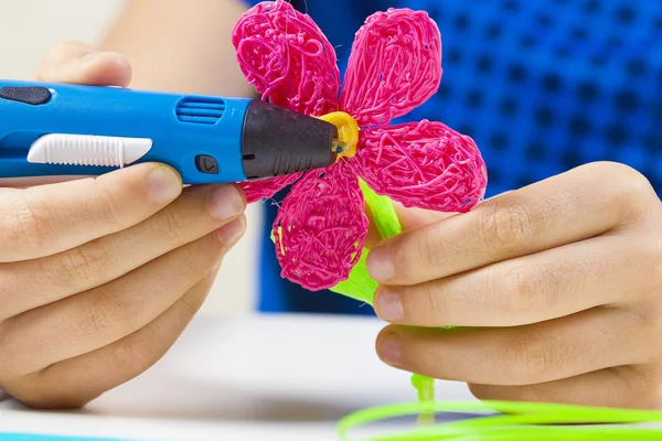 Las manos del niño sosteniendo la pluma azul de la impresión 3D y haciendo el nuevo artículo —  Fotos de Stock