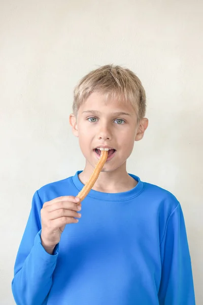 Barn äter svettas spanska dessert churros — Stockfoto