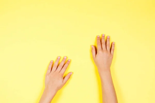 Dos niños manos sobre fondo amarillo —  Fotos de Stock