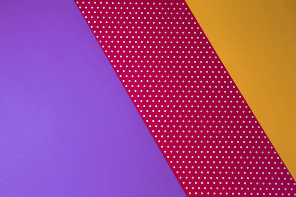 Abstract geometric yellow, purple and polka dot paper background.