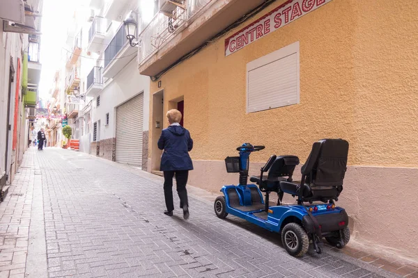 A los turistas les gusta usar scooters de movilidad contratada en la calle de Benidorm, España — Foto de Stock