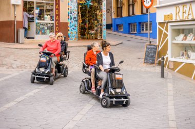 Benidorm, İspanya sokakta Kiralık hareketlilik scooter kullanarak kadınlar