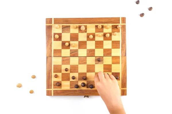 Chess board with chess pieces and a kid hand. — Stock Photo, Image