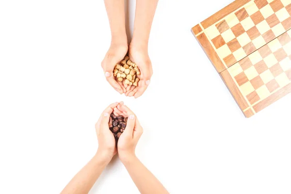 Top view of kid hand and chess board with chess pieces — Stock Photo, Image