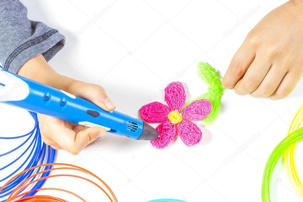 Kid hand holding blue 3d printing pen and making new item