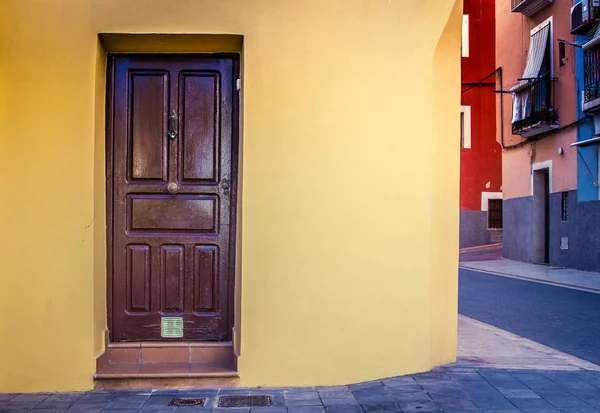 Braune Tür und gelbe Hausfassade in der Straße — Stockfoto