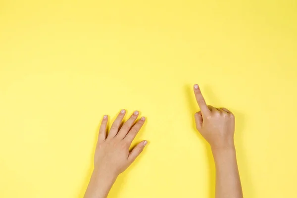Niños manos apuntando sobre fondo amarillo — Foto de Stock