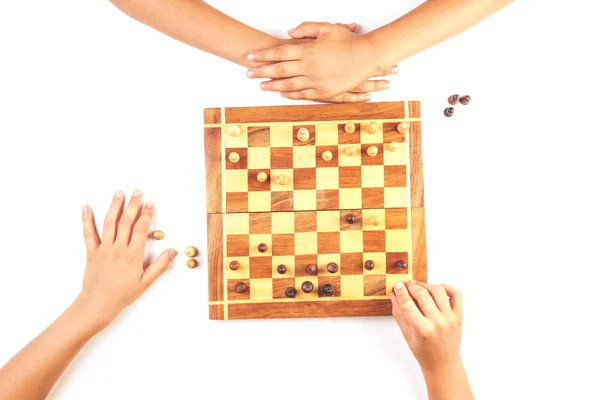 Chess board with chess pieces and a playing kids hand. — Stock Photo, Image