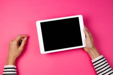 Tablet bilgisayarda pembe bir arka plan ile kadının el.