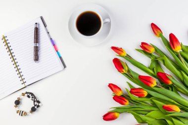 Ofis resepsiyon masası kağıt defter, kalem, kahve fincanı ve güzel taze demet çiçek Lale