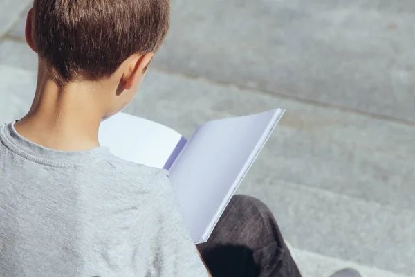 Young Boy leesboek buitenshuis — Stockfoto