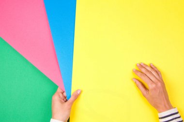 Yeşil, pembe, mavi ve yeşil kağıt örnekleri tutan el ile renk kağıtları geometri düz kompozisyon