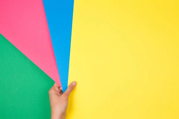 Geometría de papeles de color composición plana con la mano femenina sosteniendo muestras de papel verde, rosa, azul y verde — Foto de Stock