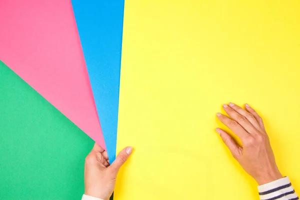 Barevné papíry geometrie plochá kompozice s ženské ruky držící vzorky papíru zelené, růžové, modré a zelené — Stock fotografie