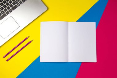 Üstten Görünüm office tablo Resepsiyon. Dizüstü bilgisayar ve açık defter renkli arka plan üzerinde mor kalem ile çalışma alanı.