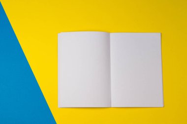 Sarı ve mavi renk arka plan üzerine açık boş kağıt defter.