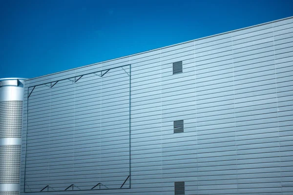 Cadre en acier de panneau d'affichage blanc sur la façade du bâtiment de style industriel sous le ciel bleu — Photo