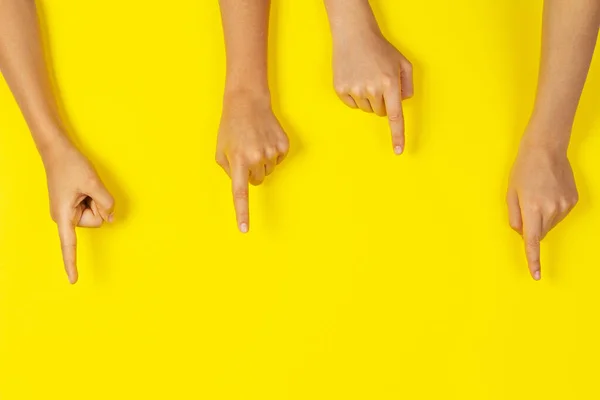 Muchas manos de niños señalando algo sobre fondo amarillo — Foto de Stock