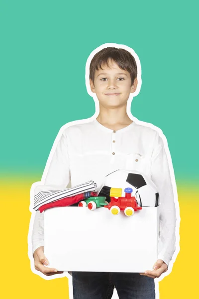 Donationskoncept. Ungen håller donera låda med kläder, böcker, skolmaterial och leksaker. Magasin collage stil med ljusgrön och gul färg bakgrund — Stockfoto