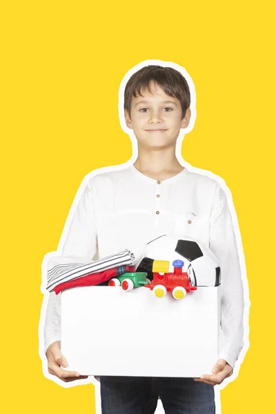 Donationskoncept. Ungen håller donera låda med kläder, böcker, skolmaterial och leksaker. Magasin collage stil med gul färg bakgrund — Stockfoto