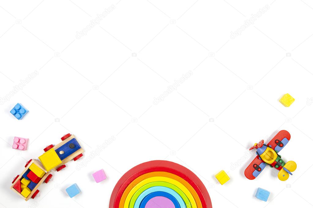 Baby kids toys background with wooden train, rainbow, plane and colorful blocks. Top view, flat lay