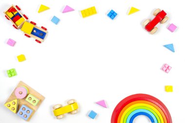 Bebek çocukların oyuncak geçmişi. Tahta eğitim geometrik istif blokları oyuncakları, ahşap tren, araba, gökkuşağı, uçak ve beyaz arka planda renkli bloklar. Üst manzara, düz uzanma