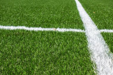 Beyaz çizgili yeşil sentetik çimen futbol sahası