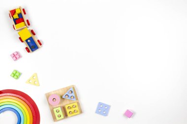 Bebek çocukların oyuncak geçmişi. Tahta eğitici geometrik istif blokları oyuncakları, tahta gökkuşağı ve beyaz arka planda renkli bloklar. Üst manzara, düz uzanma