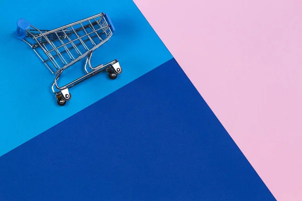 Mini shopping trolley cart on pastel pink, light blue and navy color background. Online shopping, buy, sale, discount concept — 스톡 사진