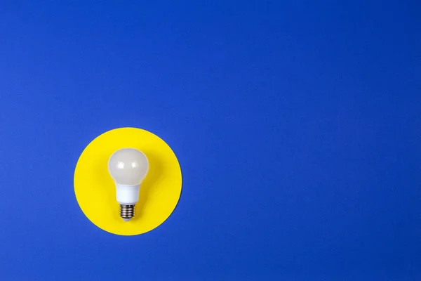 One light lamp bulb on yellow and navy blue background — Stock Photo, Image