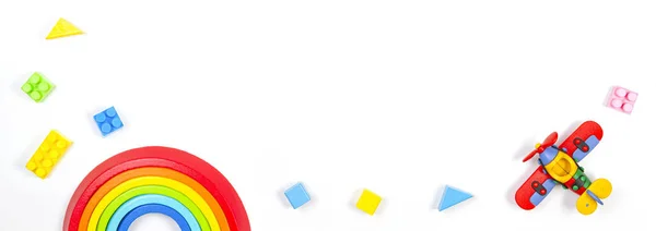 Baby kinderen speelgoed banner achtergrond. Constructor vliegtuig, stapelen speelgoed regenboog en kleurrijke blokken op witte achtergrond. Bovenaanzicht, vlak lay — Stockfoto