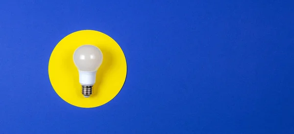 One light lamp bulb on yellow and navy blue background — Stock Photo, Image