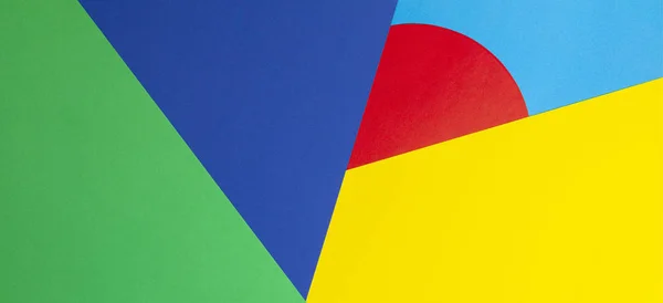 Forma geométrica abstracta amarillo, azul, rojo, fondo de papel de color verde — Foto de Stock