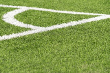 Yeşil suni çim sahası futbol sahası, beyaz köşeli saha sınırı. Üst görünüm