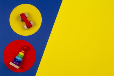 Bebek çocukların oyuncak geçmişi. Tahta istifleme piramit kulesi ve kırmızı oyuncak araba sarı ve kırmızı çerçeveler üzerinde lacivert arka plan üzerinde