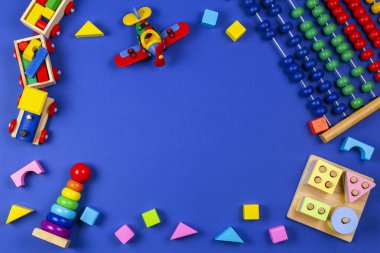 Bebek çocukların oyuncak geçmişi. Tahta eğitim geometrik istif blokları oyuncakları, ahşap tren, kırmızı uçak ve lacivert arka planda renkli bloklar. Üst manzara, düz uzanma