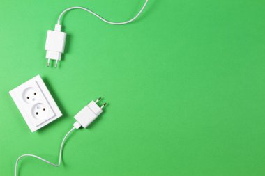 Beyaz elektrik prizleri ve açık yeşil arka planda elektrik prizi. Üst görünüm