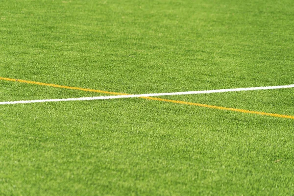 Groene kunstgras gras voetbal voetbalveld achtergrond met witte en gele lijn grens. Bovenaanzicht — Stockfoto