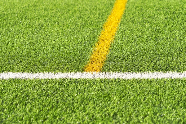 Zielona trawa sztuczna trawa boisko do piłki nożnej tło z białej i żółtej granicy linii. Widok z góry — Zdjęcie stockowe