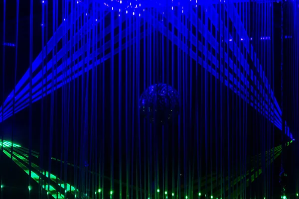 Zielone i niebieskie wiązki laserowe na czarnym tle. Strumień promieni laserowych — Zdjęcie stockowe