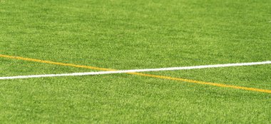Yeşil yapay çimen sahası futbol sahası arka planı beyaz ve sarı çizgi sınırlı. Üst görünüm