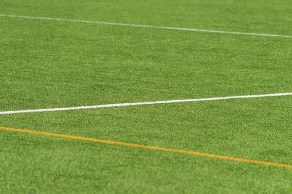 Groene kunstgras gras voetbal voetbalveld achtergrond met witte en gele lijn grens. Bovenaanzicht — Stockfoto