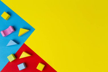 Geometrik sarı mavi arka planda ahşap renkli bloklar. Üst görünüm