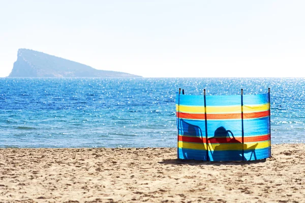 Dwie osoby relaksujące się za kolorową szybą w paski Plaża Poniente nad Morzem Śródziemnym w Benidorm, Hiszpania — Zdjęcie stockowe