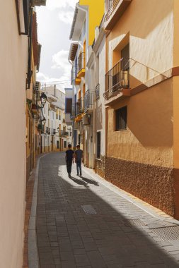 Çocuklar güneşli bir günde boş Avrupa sokaklarında yürüyorlar.