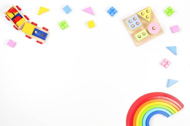 Bebek çocukların oyuncak geçmişi. Tahta eğitici geometrik istifleme blokları oyuncak, gökkuşağı, ahşap tren ve beyaz arka planda renkli bloklar. Üst manzara, düz uzanma