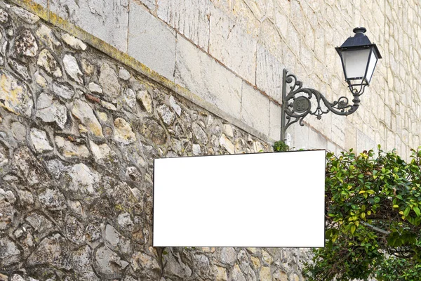 Faz asneira. Placa publicitária branca da tabuleta em branco, placa da informação na parede velha da pedra na cidade européia — Fotografia de Stock