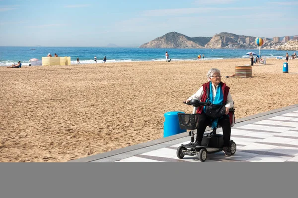 Benidorm, Spain - February 25, 2020: Woman with mobility scooter in Levante beach area in Benidorm, Spain — Stock Photo, Image